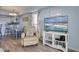 Comfortable living room with TV and decorative shelving unit, adjacent to the dining area and kitchen at 126 N Waccamaw Dr. # 101, Garden City Beach, SC 29576
