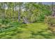Lush backyard with a charming wooden walkway through a serene wooded area at 130 Hagar Brown Rd., Murrells Inlet, SC 29576