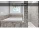 Modern bathroom features a soaking tub with stone surround and tiled walk-in shower at 130 Hagar Brown Rd., Murrells Inlet, SC 29576