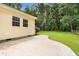 Backyard patio and yard surrounded by mature trees shows the rear of the house at 131 Oak Log Lake Rd., Conway, SC 29526
