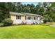 Cozy single-story home featuring a well-manicured lawn, a quaint porch and a welcoming entrance at 131 Oak Log Lake Rd., Conway, SC 29526