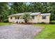 Charming yellow home featuring a metal roof, blue shutters, and well-maintained landscaping at 131 Oak Log Lake Rd., Conway, SC 29526