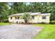 Charming single-story home with a gravel driveway, lush lawn and inviting front porch at 131 Oak Log Lake Rd., Conway, SC 29526