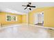 Open-concept living room with yellow walls, tile floors, and natural light from large windows at 131 Oak Log Lake Rd., Conway, SC 29526