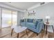 Bright living room with a blue sofa, tulip artwork, and sliding glass door, creating an airy space at 1356 Glenns Bay Rd. # 208M, Surfside Beach, SC 29575