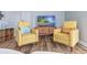 Bright living room featuring two yellow armchairs, coastal decor, and a beach-themed TV display at 1356 Glenns Bay Rd. # 208M, Surfside Beach, SC 29575