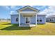 View of the backyard featuring sliding glass doors and a covered patio with white support pillars at 1368 Palm Springs Paloma Dr, Longs, SC 29568