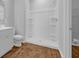 Bathroom featuring a tiled shower, wood-look flooring, and toilet at 1368 Palm Springs Paloma Dr, Longs, SC 29568