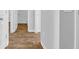 Hallway with wood-look flooring leading to bathroom with white trim and doors at 1368 Palm Springs Paloma Dr, Longs, SC 29568