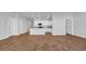 Open floor plan with modern kitchen, wood-look floors, and white cabinets at 1368 Palm Springs Paloma Dr, Longs, SC 29568