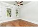 Bright bedroom showcasing hardwood floors, two large windows, and a stylish ceiling fan at 1400 James Island Ave., North Myrtle Beach, SC 29582