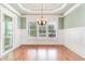 Bright dining room with hardwood floors, wainscoting, and large windows offering serene views at 1400 James Island Ave., North Myrtle Beach, SC 29582