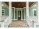 Inviting front porch with detailed columns, warm wood ceiling, and stylish front door at 1400 James Island Ave., North Myrtle Beach, SC 29582