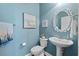 Cozy bathroom with blue walls, stylish decor, and a decorative round mirror at 1470 Suncrest Dr., Myrtle Beach, SC 29577
