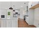 A modern kitchen with white cabinets, marble countertops, and stainless steel appliances, open to the living space at 1503 Red Bluff Rd., Loris, SC 29569