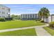 Backyard featuring manicured lawn, waterfront views, and a community BBQ pit on a sunny day at 1525 Lanterns Rest Rd. # 103, Myrtle Beach, SC 29579