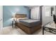 Cozy bedroom with a gray quilted bedspread and light blue accent wall at 1525 Lanterns Rest Rd. # 103, Myrtle Beach, SC 29579