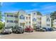 Well-maintained condo building with classic white facade, balconies, and ample parking at 1525 Lanterns Rest Rd. # 103, Myrtle Beach, SC 29579