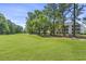 Scenic view of golf course with lush green fairways and mature trees, bordering white condo buildings at 1525 Lanterns Rest Rd. # 103, Myrtle Beach, SC 29579