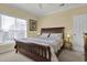 Comfortable bedroom with a wooden sleigh bed and a sunlit window view at 156 Via Old Sound Blvd. # C, Ocean Isle Beach, NC 28469