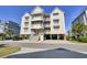 Charming three-story condo with multiple balconies and convenient covered parking, set against a bright blue sky at 156 Via Old Sound Blvd. # C, Ocean Isle Beach, NC 28469