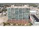 An aerial view of a condominium building, surrounded by trees and other low rise commercial buildings at 1707 Perrin Dr. # 1003, North Myrtle Beach, SC 29582