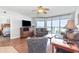 Living room with comfortable seating and view to bedroom and balcony with ocean view at 1707 Perrin Dr. # 1003, North Myrtle Beach, SC 29582