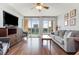 Comfortable living room featuring a cozy gray sofa and access to a private balcony at 1707 Perrin Dr. # 802, North Myrtle Beach, SC 29582