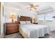 Comfortable main bedroom featuring a ceiling fan, lamps, and large windows providing lots of natural light at 1707 Perrin Dr. # 802, North Myrtle Beach, SC 29582