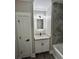 Bathroom featuring vanity with unique mirror, tub with tile surround, and wood look flooring at 1795 Hemingway St., Conway, SC 29527