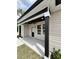 Inviting covered front porch with black pillars, neutral siding and a ceiling fan at 1795 Hemingway St., Conway, SC 29527