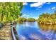 Scenic lake view with a wooden dock surrounded by lush greenery under a blue sky at 1795 Hemingway St., Conway, SC 29527