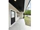 Inviting front porch with a black ceiling fan, black door and neutral colored siding at 1795 Hemingway St., Conway, SC 29527