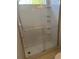 Features glass shower doors, tile walls, shelving, and a showerhead in a well-lit bathroom at 193 Charter Dr. # E3, Longs, SC 29568