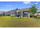 Lush backyard with a screened porch, well-maintained lawn, and view of neighboring houses at 194 Zostera Dr., Little River, SC 29566