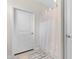 Bathroom features a tiled floor, a shower with a curtain, and a door to the outside at 194 Zostera Dr., Little River, SC 29566