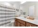 Well-lit bathroom featuring a modern vanity, neutral color palette, and decorative striped shower curtain at 194 Zostera Dr., Little River, SC 29566