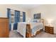 Cozy bedroom with a wooden bed frame, blue accents, and natural light from the window at 194 Zostera Dr., Little River, SC 29566