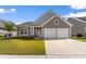 Charming home featuring a two-car garage, well-kept lawn, and appealing architectural details at 194 Zostera Dr., Little River, SC 29566