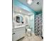 Bathroom with sleek white vanity, round mirror, shiplap accent wall and leafy shower curtain at 201 N Hillside Dr. # 311-A, North Myrtle Beach, SC 29582