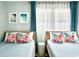 Bedroom featuring two twin beds with floral pillows and coastal artwork and curtains at 201 N Hillside Dr. # 311-A, North Myrtle Beach, SC 29582