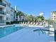 The community pool and hot tub are surrounded by lounge chairs and palm trees at 201 N Hillside Dr. # 311-A, North Myrtle Beach, SC 29582