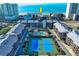 Aerial view of condo community featuring a swimming pool and blue tennis courts near the beach at 208 N Ocean Blvd. # 321, North Myrtle Beach, SC 29582