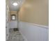 Entry hallway with neutral paint, wainscoting, tile flooring, and decorative mirror at 208 N Ocean Blvd. # 321, North Myrtle Beach, SC 29582