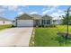 Charming single-story home featuring a well-manicured lawn, attached garage, and welcoming front entrance at 211 Seasons Trace Loop, Longs, SC 29568