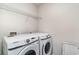 Laundry room with side-by-side Samsung washer and dryer and white wire shelving at 211 Seasons Trace Loop, Longs, SC 29568