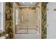 Bathroom featuring tile and glass shower doors and tropical wallpaper at 215-B S Dogwood Dr., Surfside Beach, SC 29575