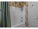 Bathroom showing shower with white tub and tropical themed wallpaper at 215-B S Dogwood Dr., Surfside Beach, SC 29575