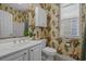 Charming bathroom with tropical wallpaper, white fixtures, and ample counter space at 215-B S Dogwood Dr., Surfside Beach, SC 29575