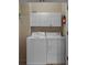 Efficient laundry room with a full-size washer, dryer, and overhead storage cabinets at 215-B S Dogwood Dr., Surfside Beach, SC 29575